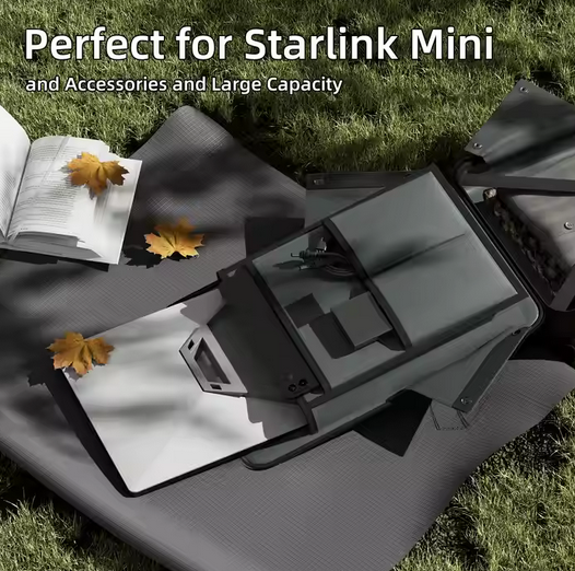 Black Starlink Mini device on a gray mat with leaves on grass